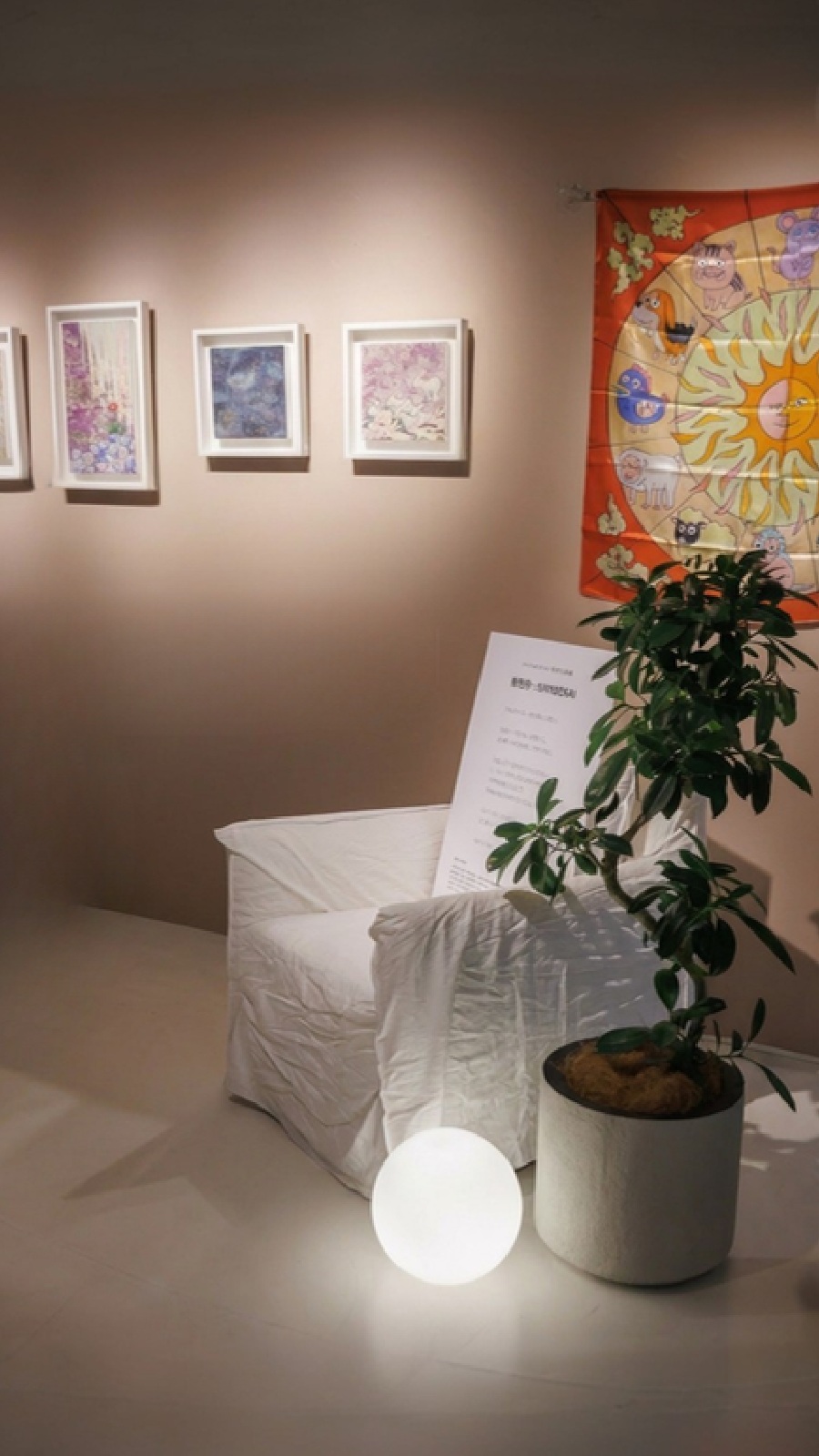 作品と白い家具、植物の展示